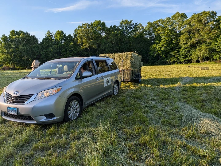 minivan pulling trailer with hay