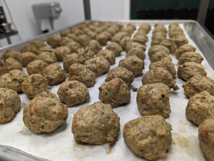 meatballs on a large sheep pan in commercial kitchen