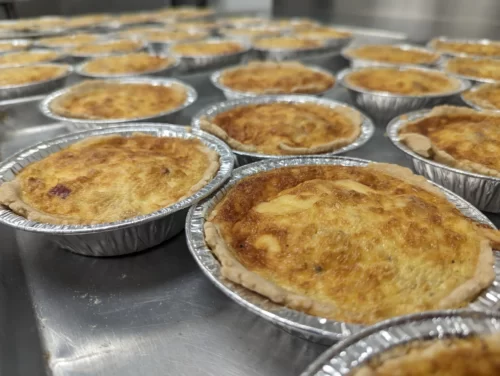 lots of personal sized quiches in commercial kitchen