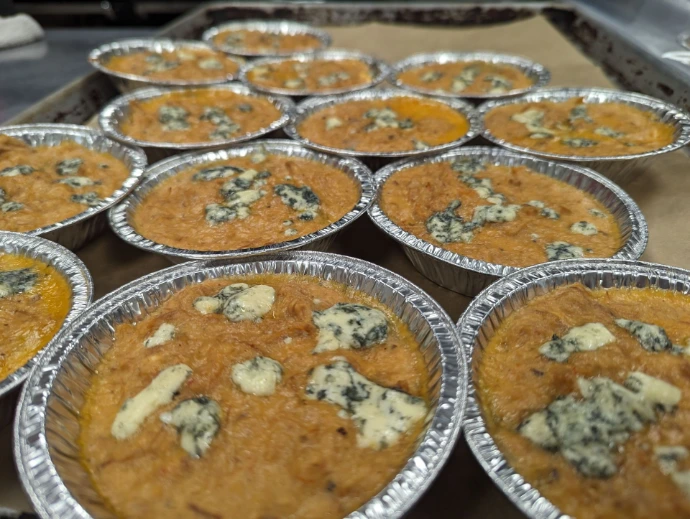 Tins of chicken dip in a commercial kitchen