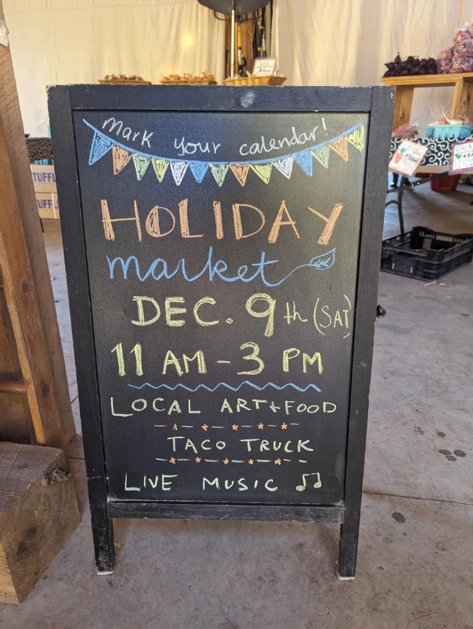 a sandwich board advertising Assawaga Farm's winter party