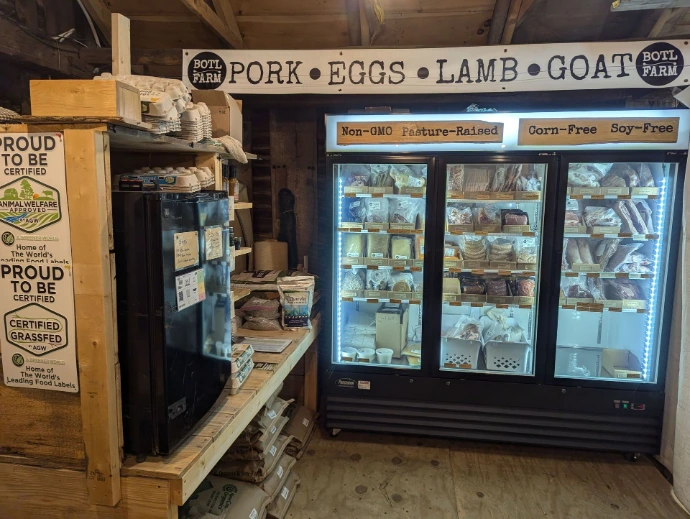 BOTL Farm's farm store with animal feed bags and upright glass front display freezer with meat