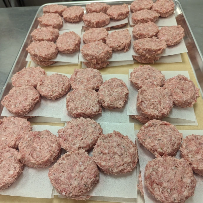 trays of sausage patties at a commercial kitchen